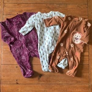 Three 3-month Carter’s long sleeved, two-way zippered onesies